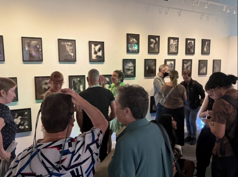 a group of people in a room with pictures on the wall