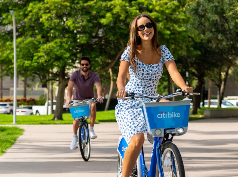 a woman riding a bike with a man in the background