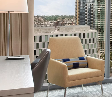 a chair and a desk in a room with a view of a city