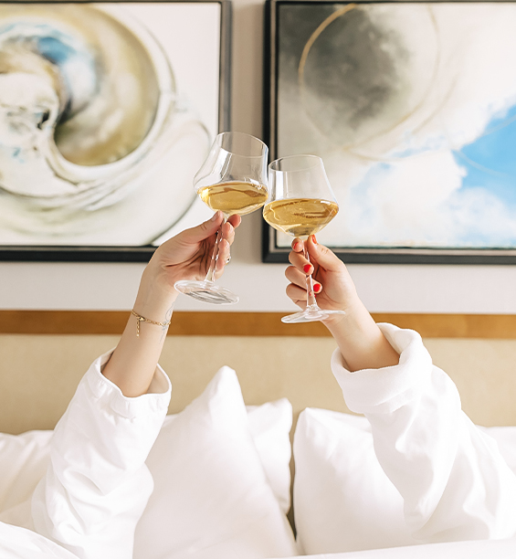 a person holding wine glasses in their hands