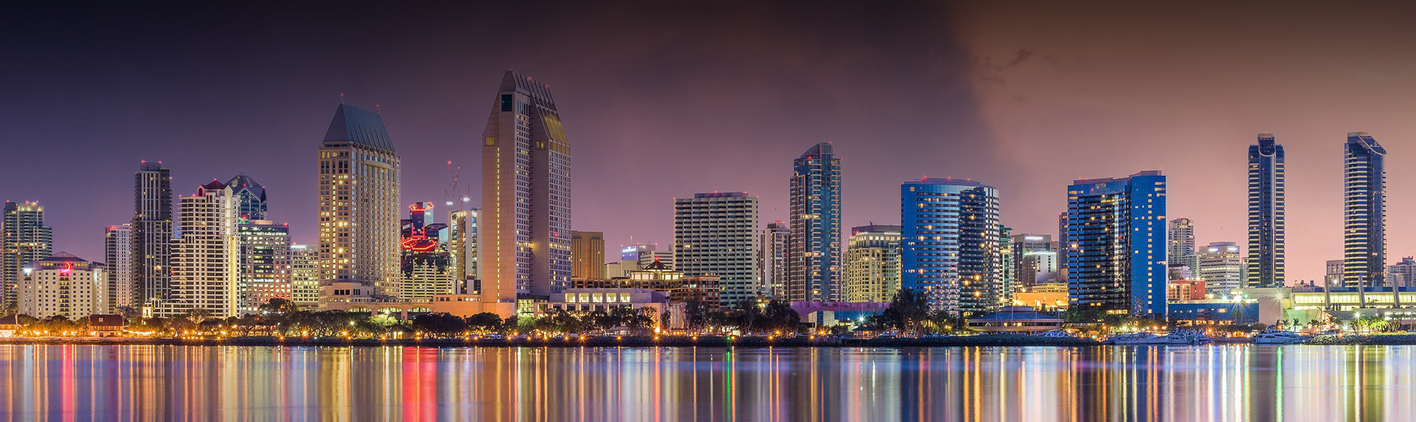 a city skyline with lights reflecting on water