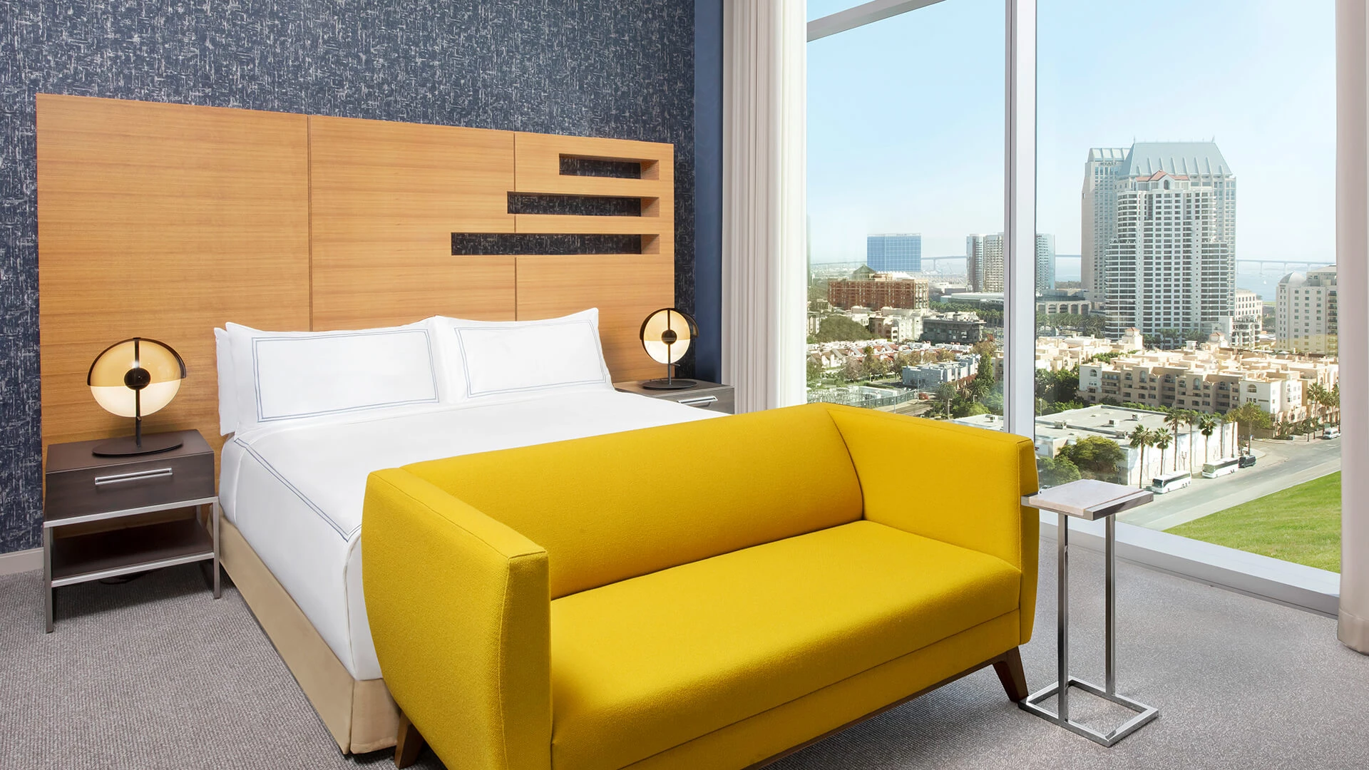 a bed with a yellow couch in a room with a window