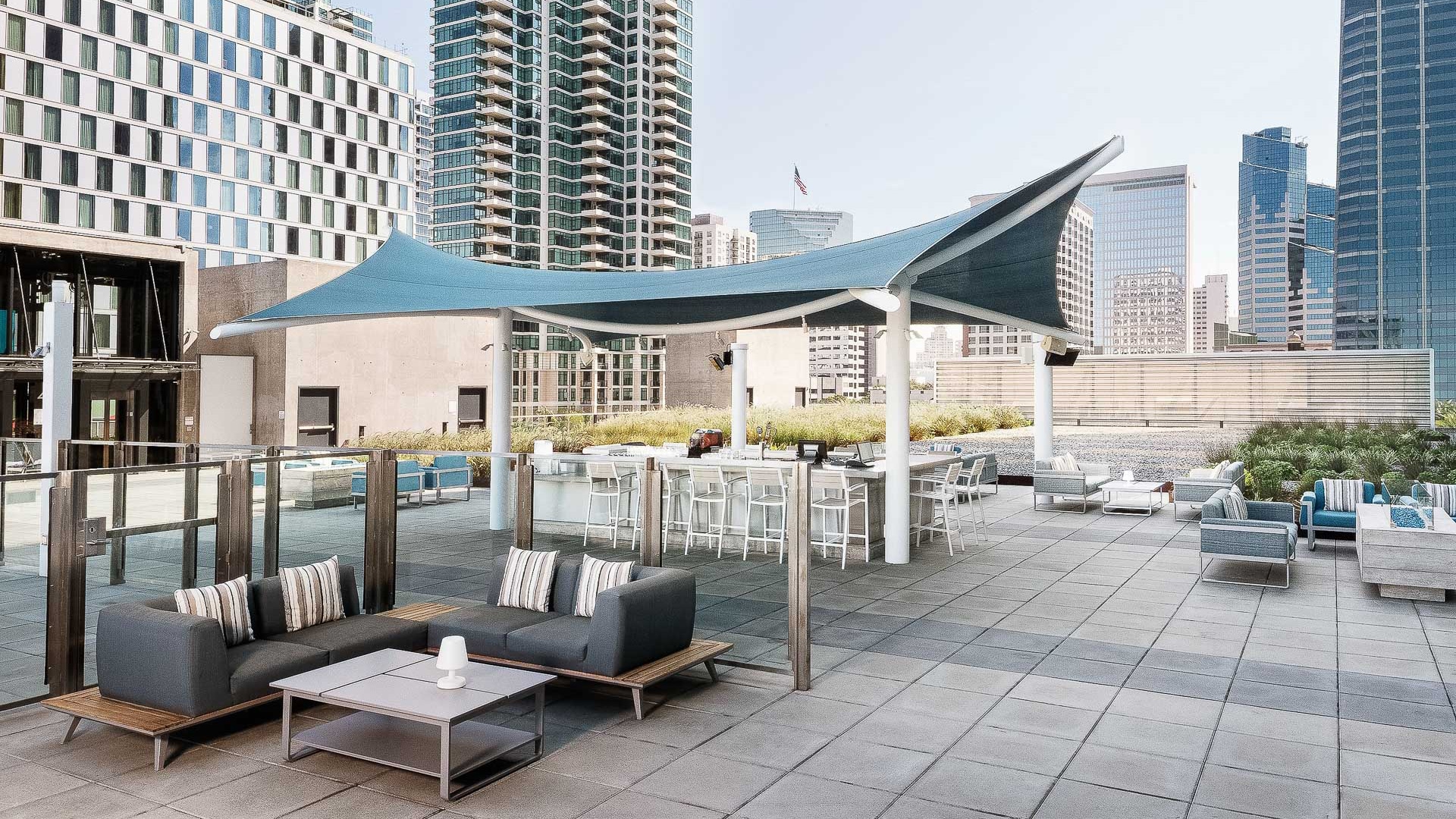 a patio with a blue awning and a large building in the background