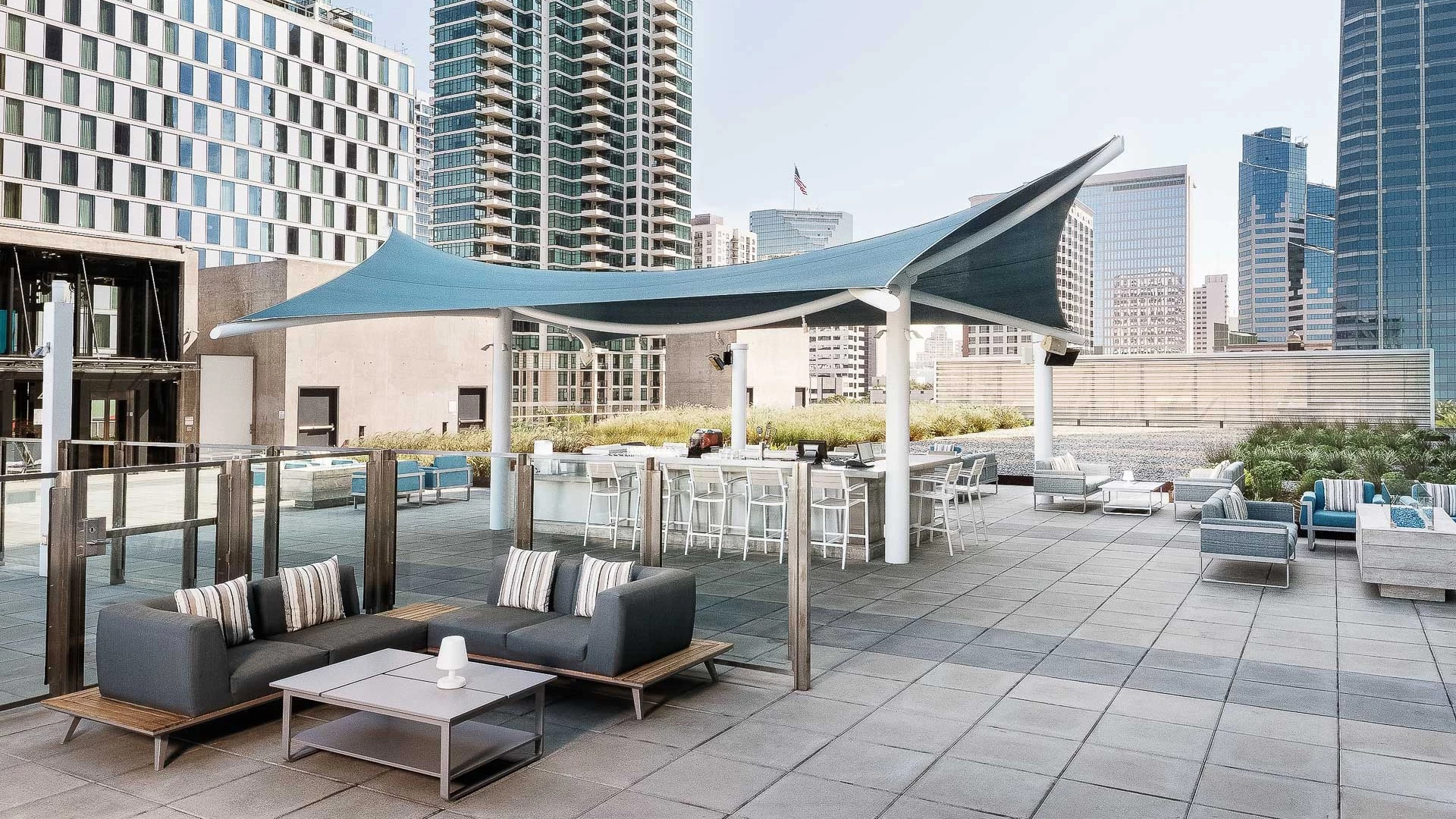 a patio with a blue awning and a large building in the background