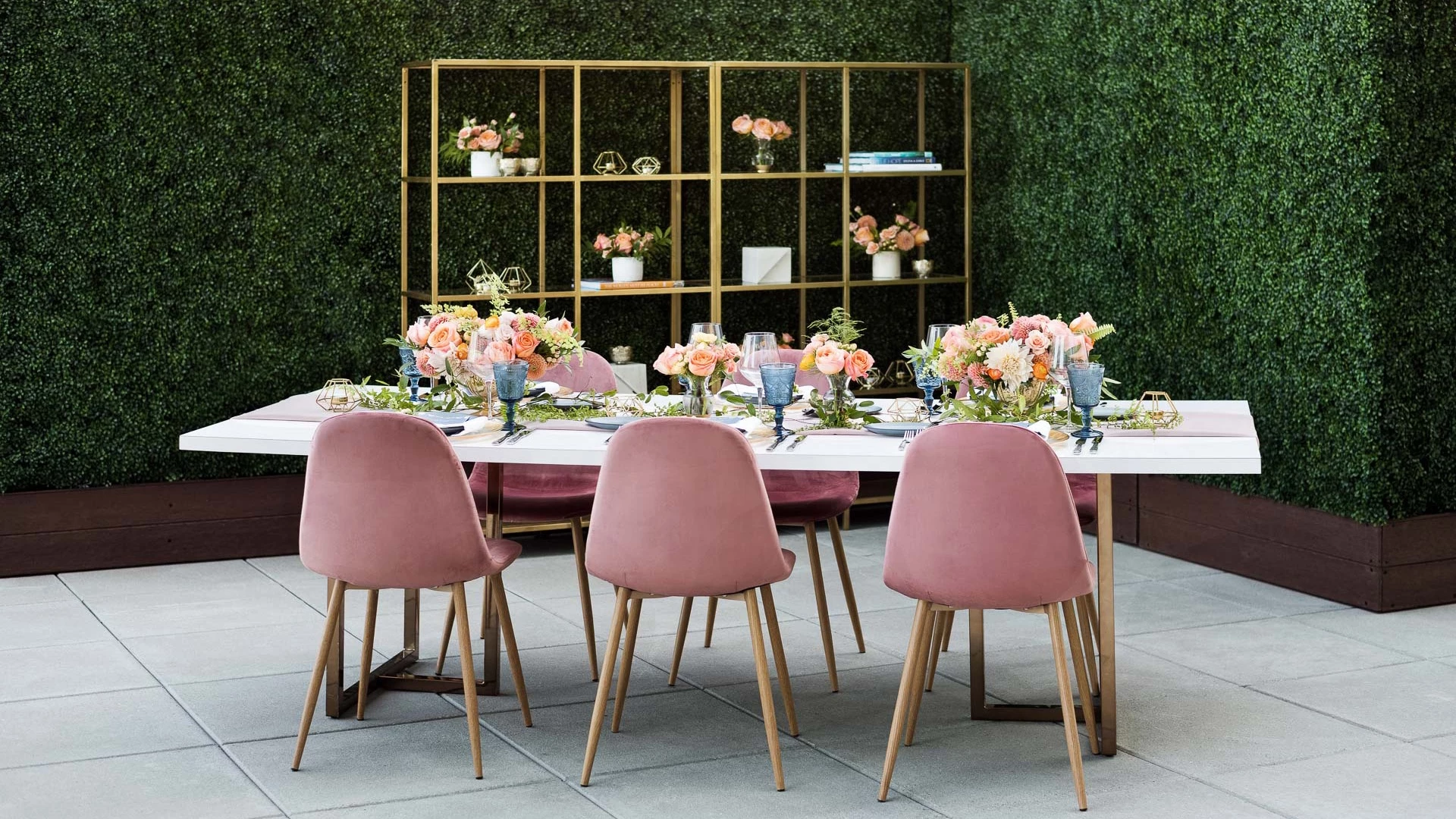 a table with pink chairs and flowers