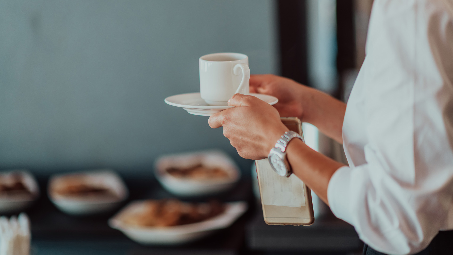 a person holding a cup and saucer
