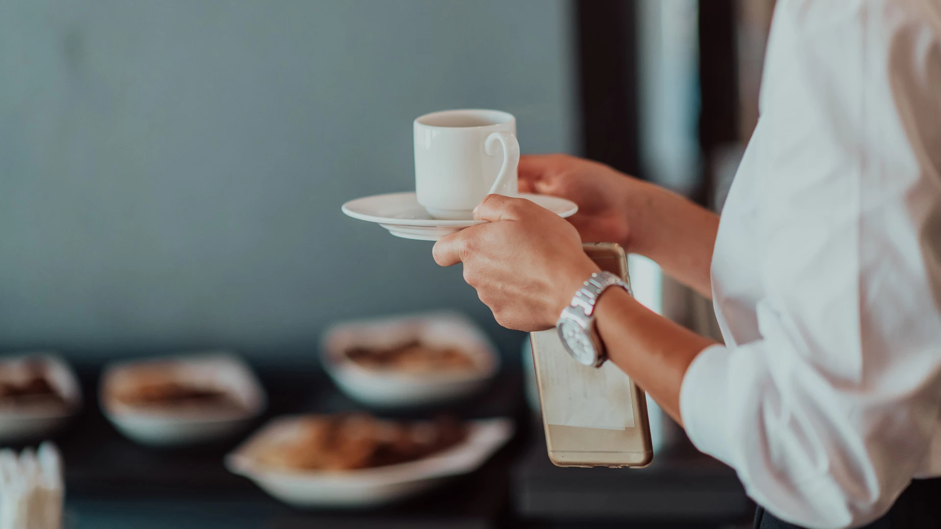 a person holding a cup and saucer