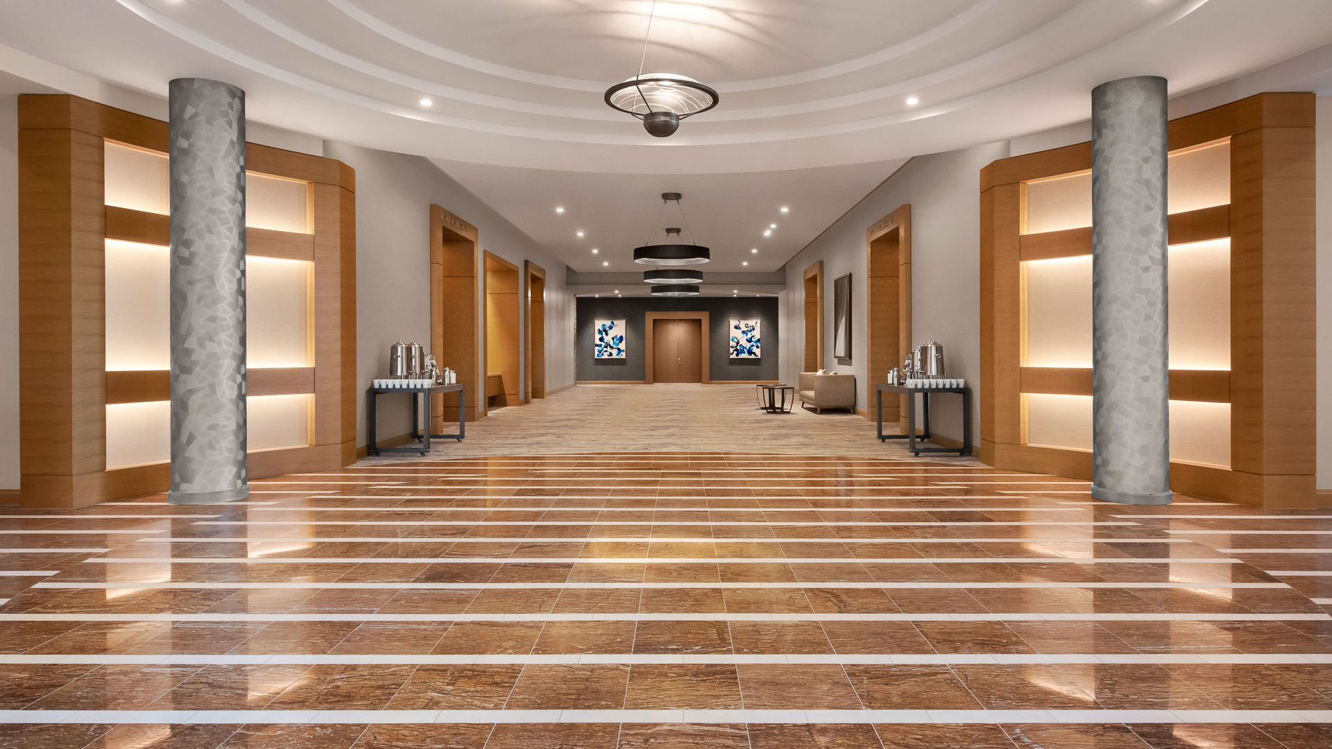 a large hall with a tile floor and a chandelier