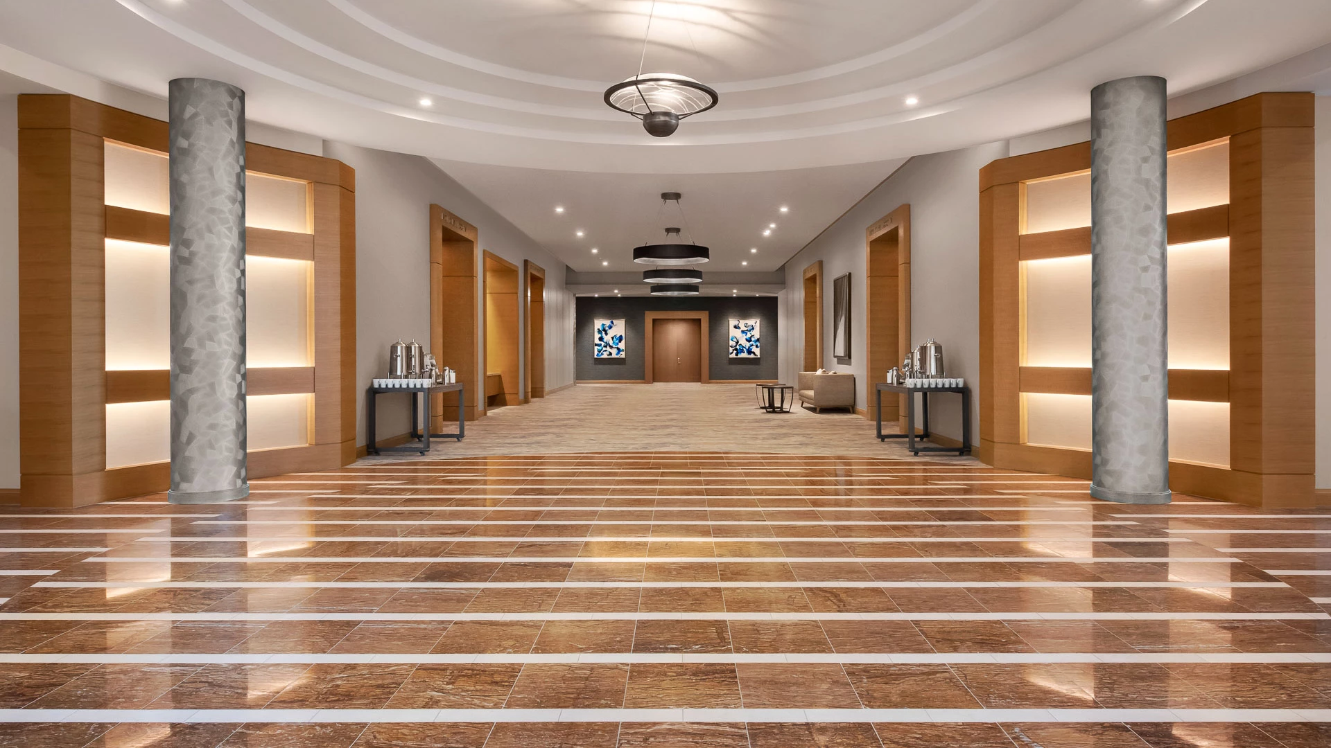 a large hall with a tile floor and a chandelier