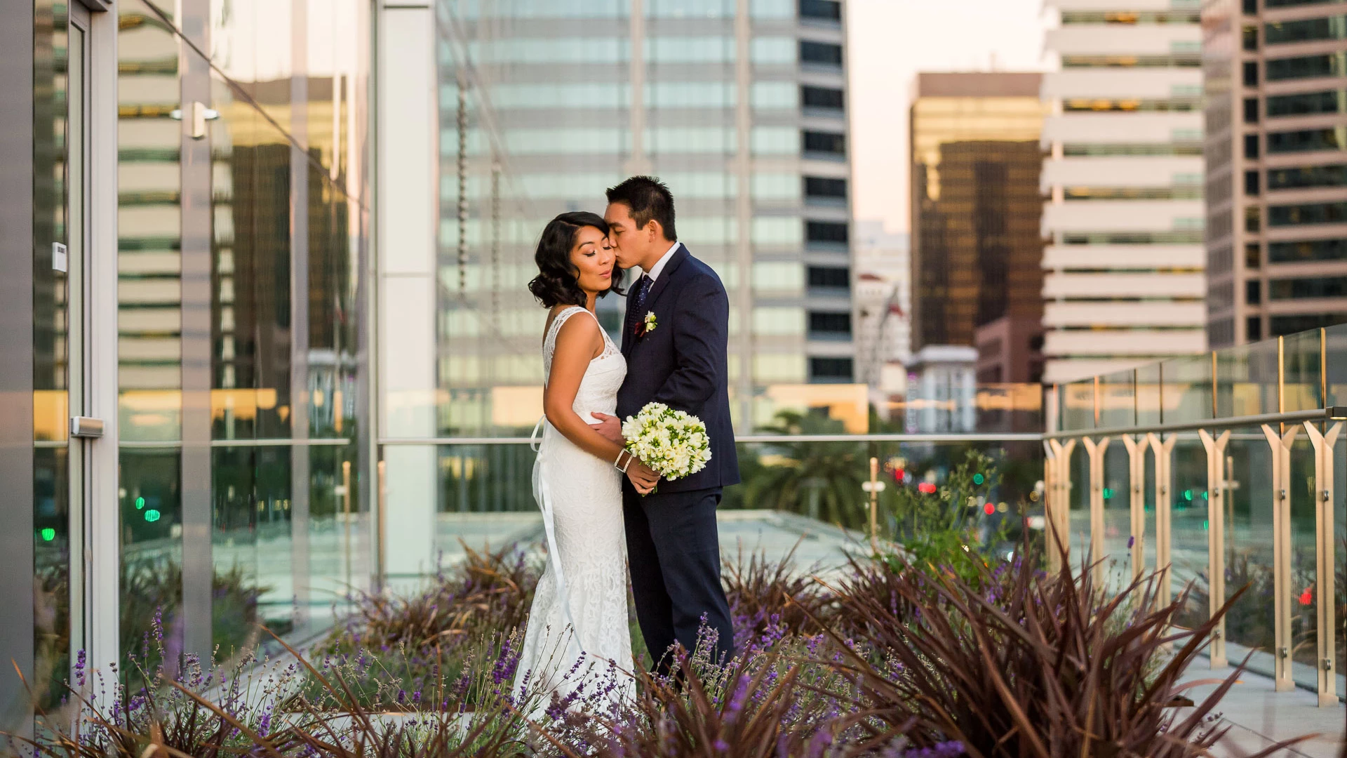 a man and woman kissing in front of a building