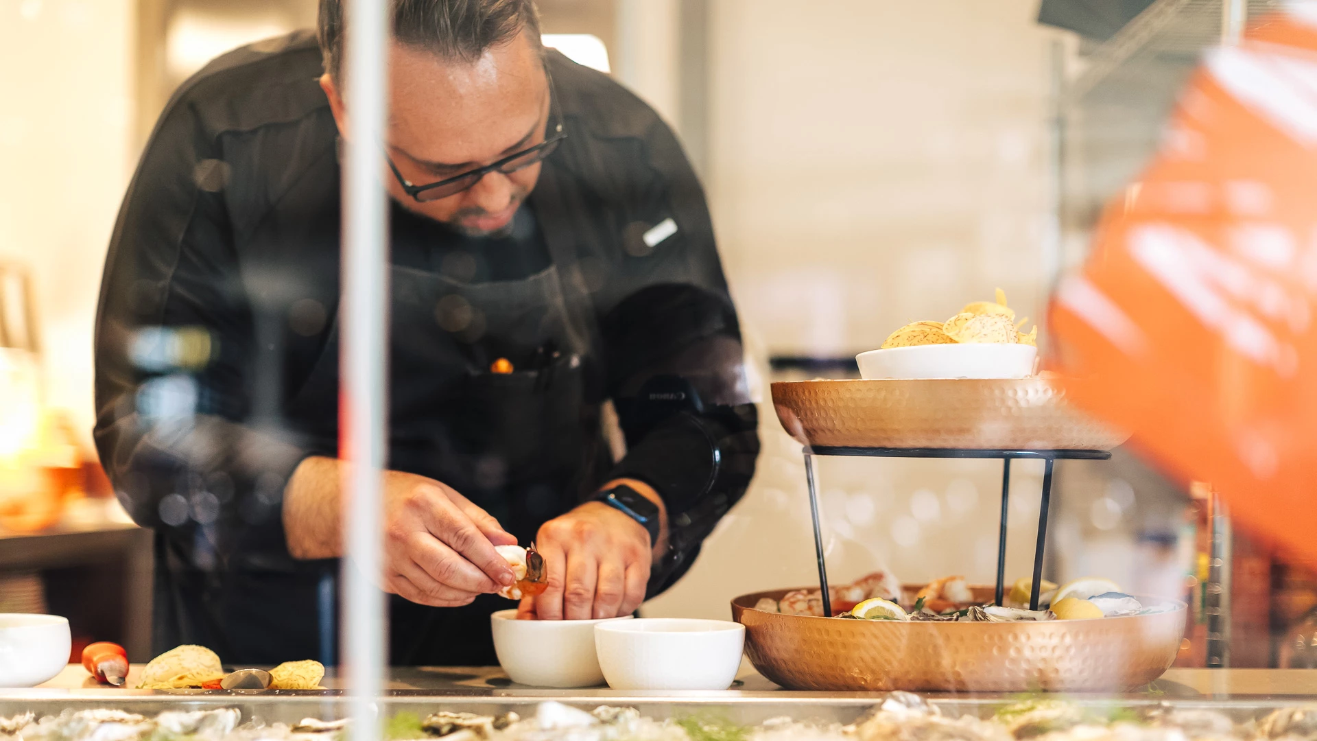 a man in a black jacket preparing food