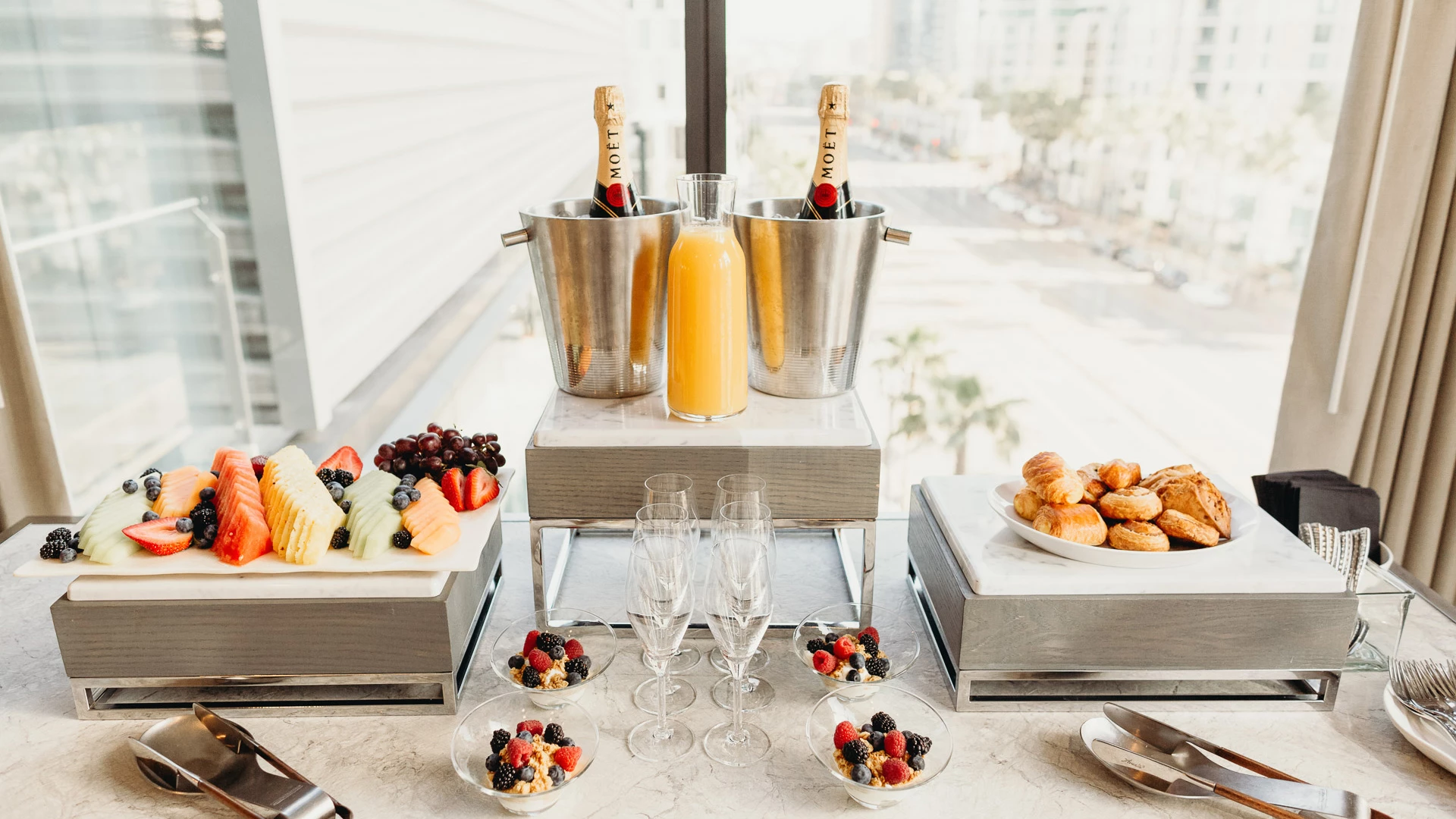 a buffet table with champagne and fruit