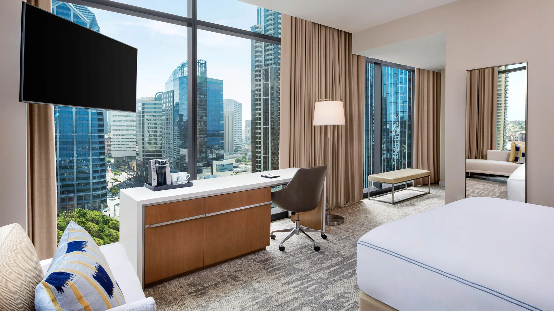 a room with a large window and a desk and a television