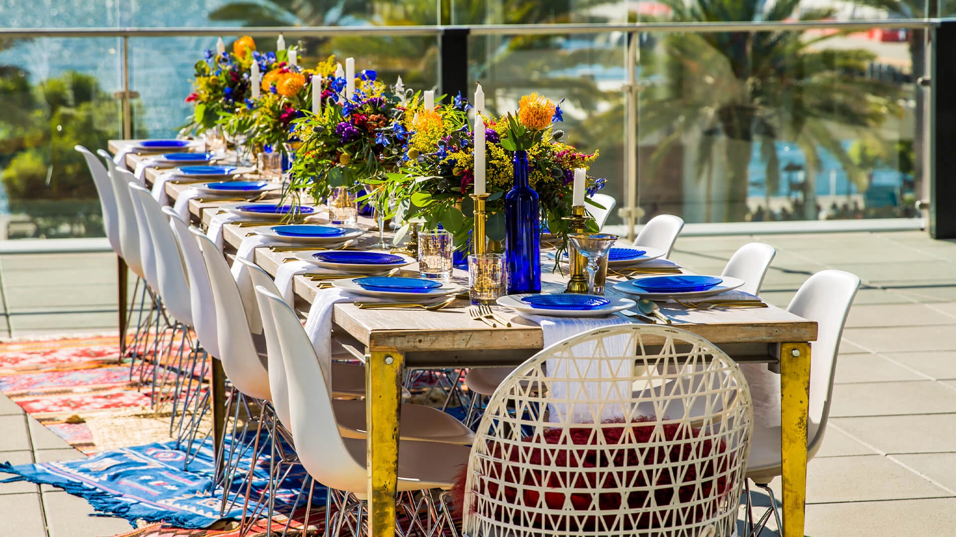 a table set with blue plates and flowers
