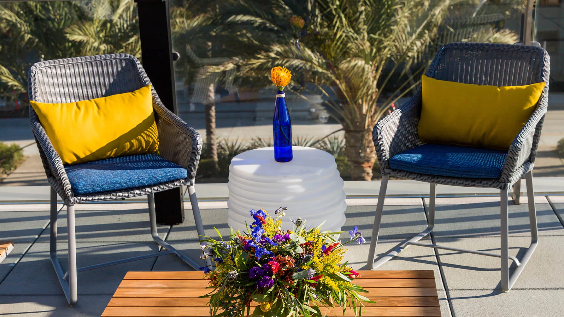 a table with chairs and a vase of flowers on it