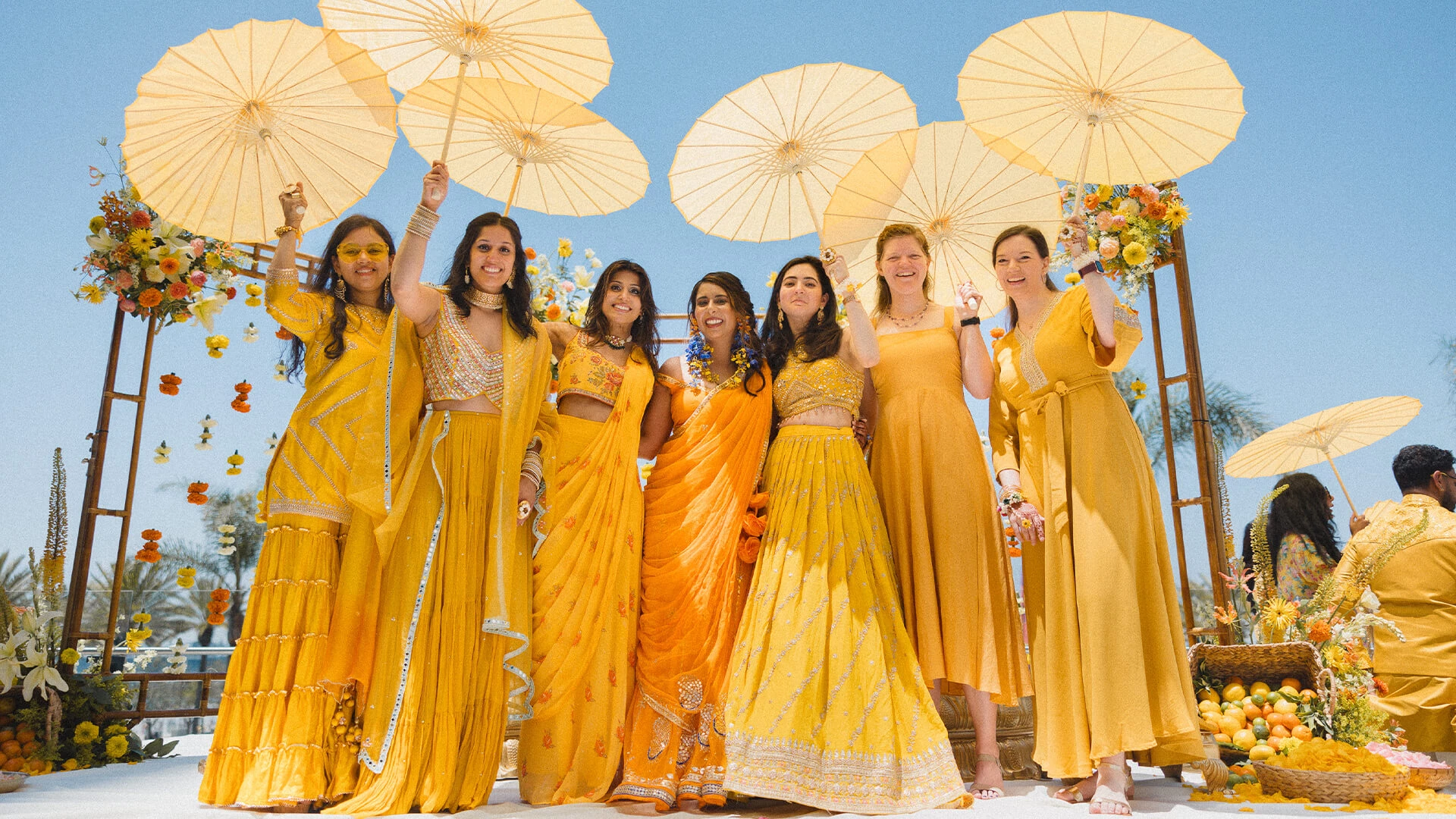 a group of women in yellow dresses holding umbrellas