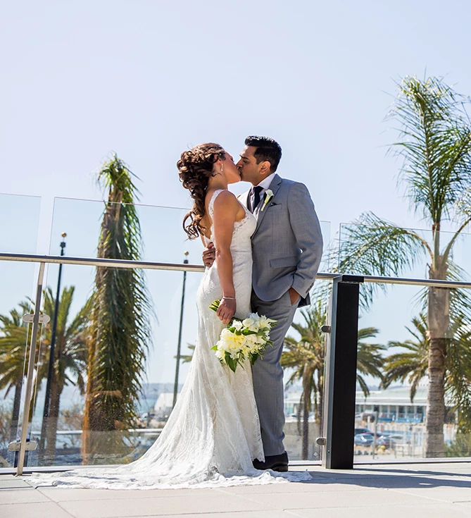 a man and woman kissing on a balcony