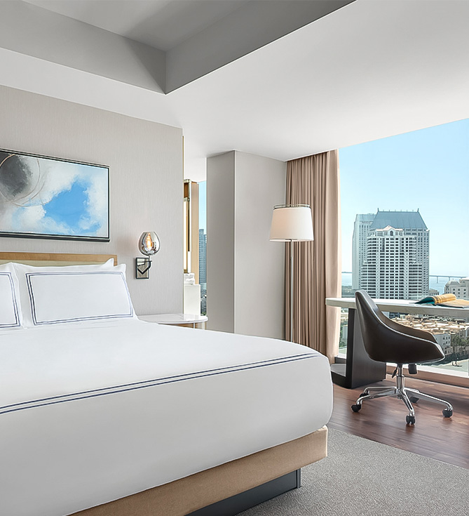 a hotel room with a large window and a large bed