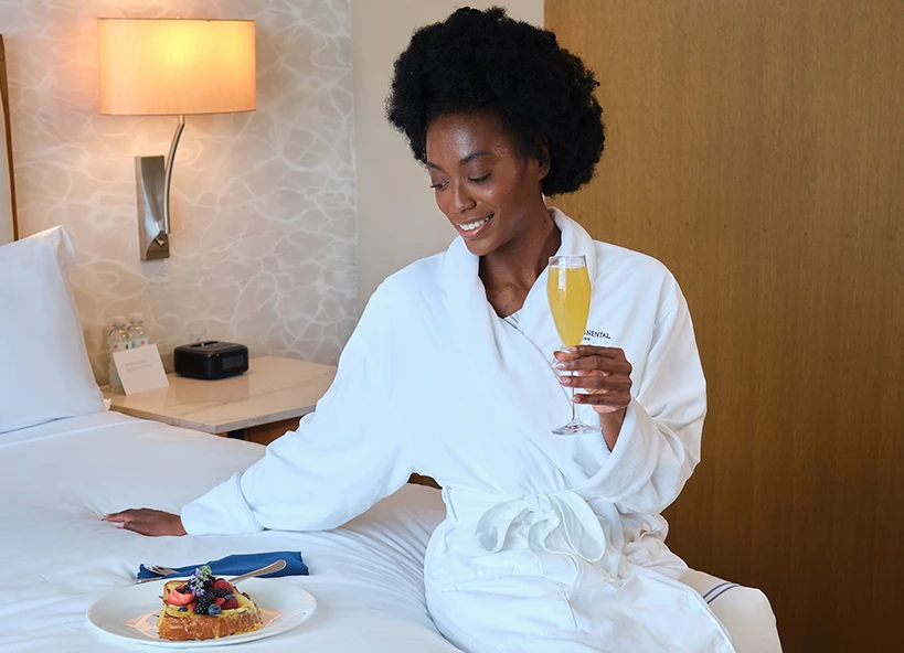 a woman in a white robe holding a glass of champagne