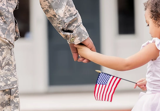a soldier holding a child's hand