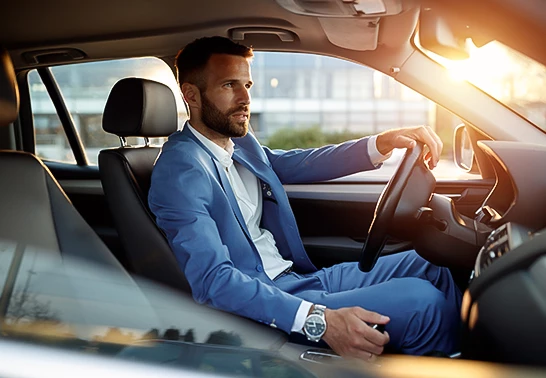 a man in a blue suit sitting in a car