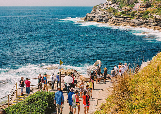 a group of people standing on a path near a body of water
