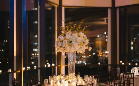 a table set up with a vase of flowers and candles