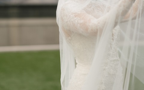 a woman in a white dress holding a veil