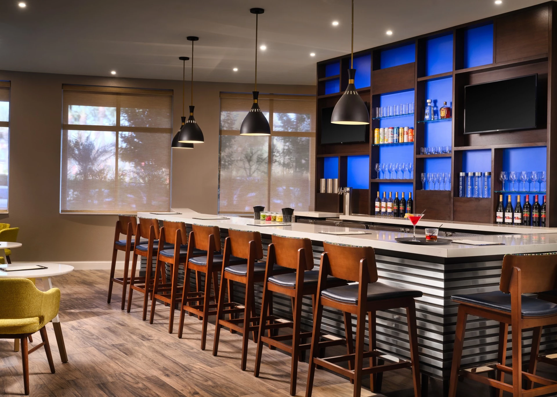 a bar with chairs and a table with drinks