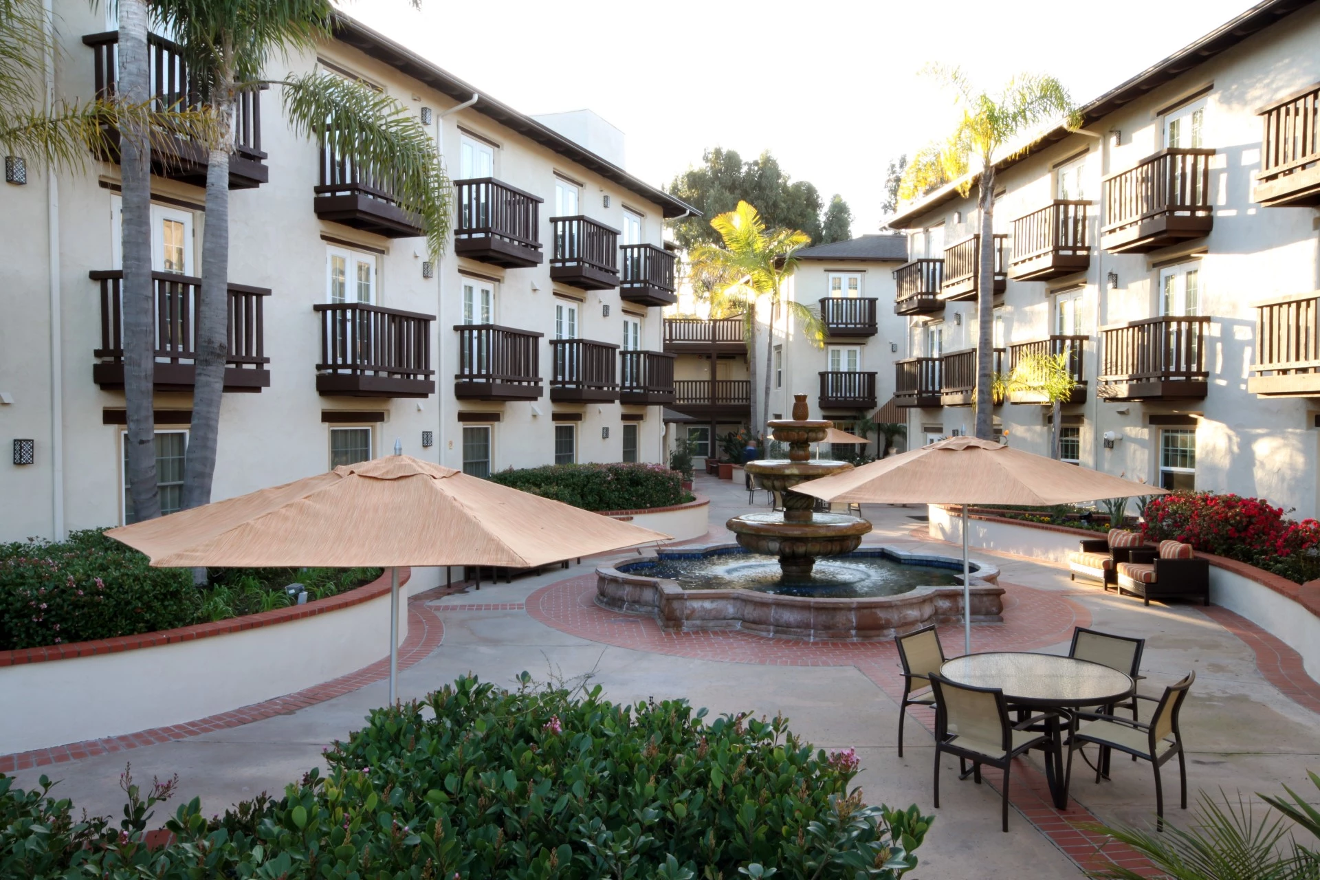 a courtyard with a fountain and umbrellas