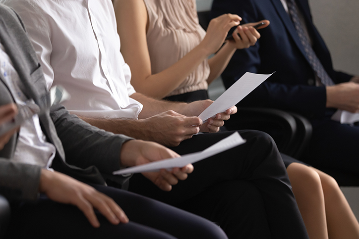 a group of people sitting in a circle holding papers
