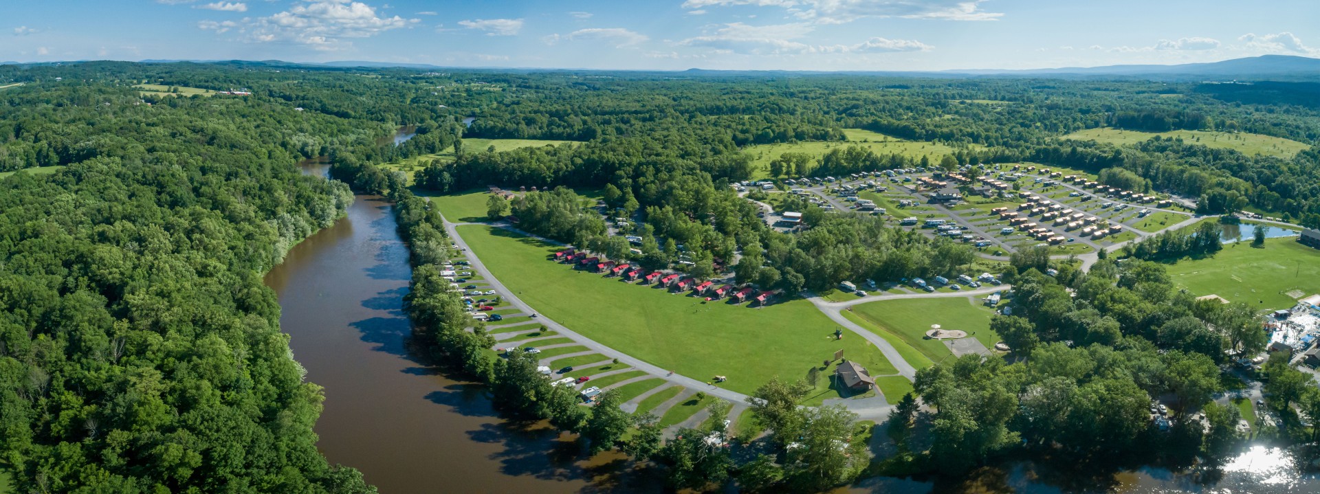 a aerial view of a park with parking lot and a river