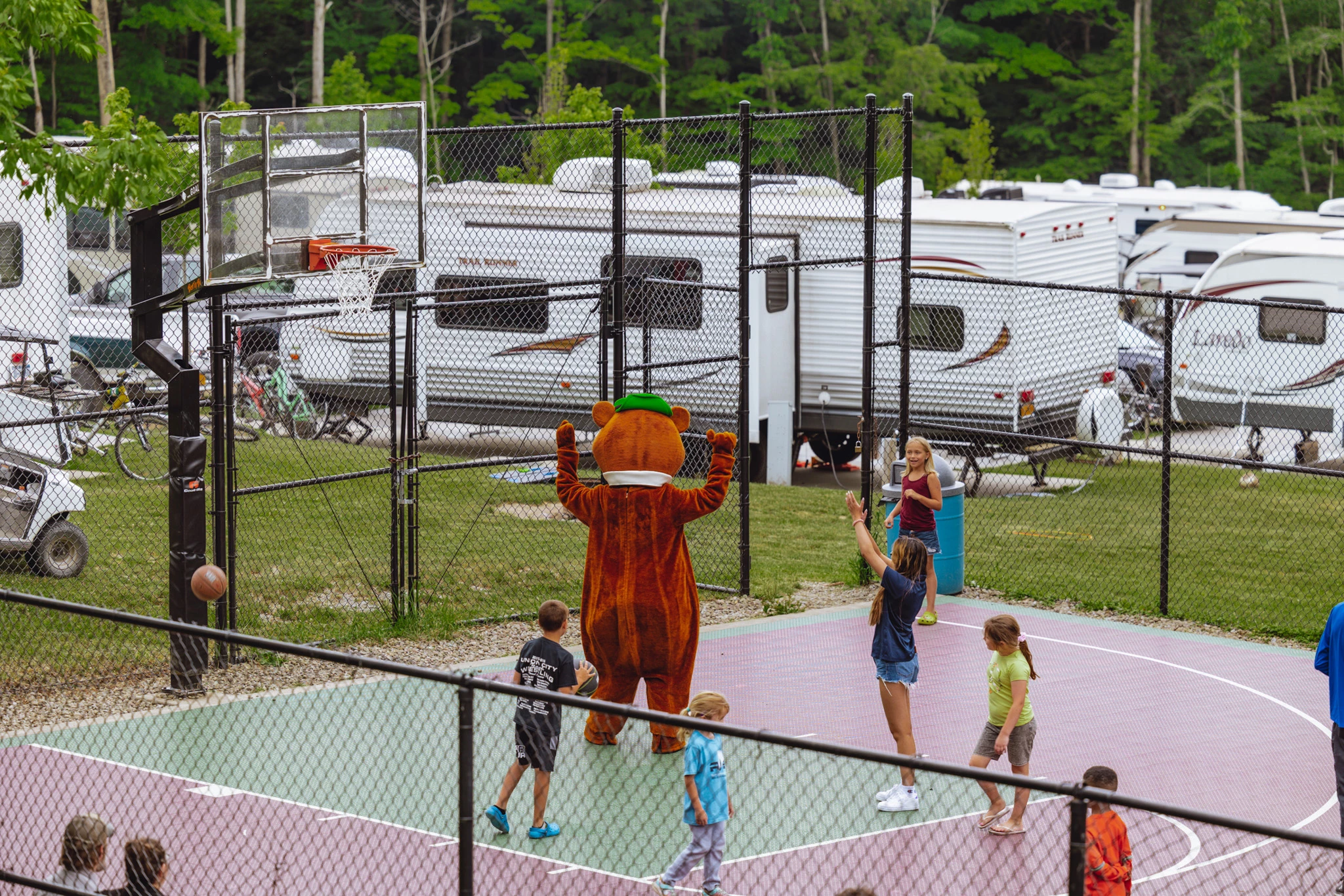 a person in a garment standing on a tennis court with a group of people