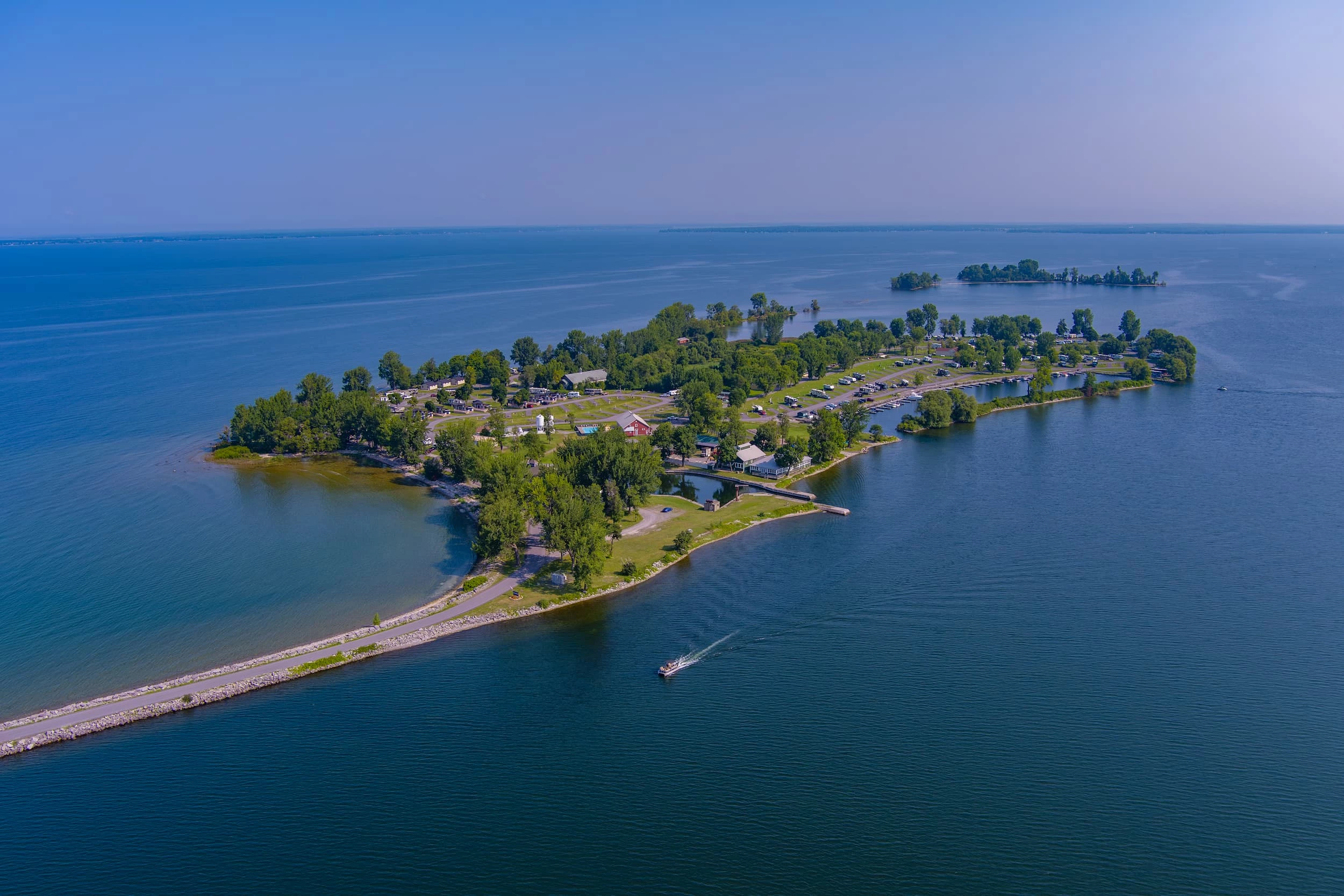 an island with trees and a boat in the water