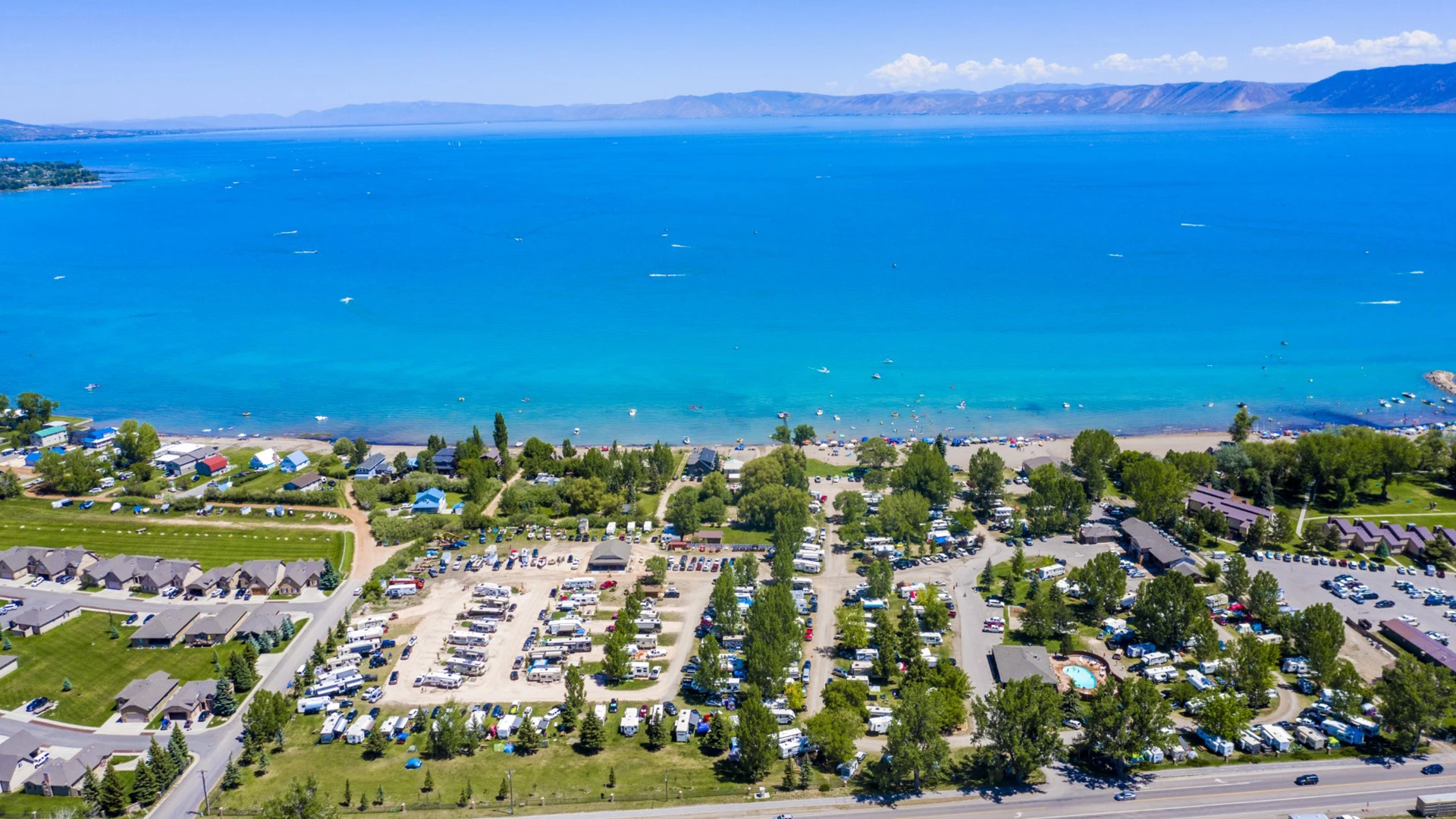 aerial view of a parking lot with a body of water and a beach