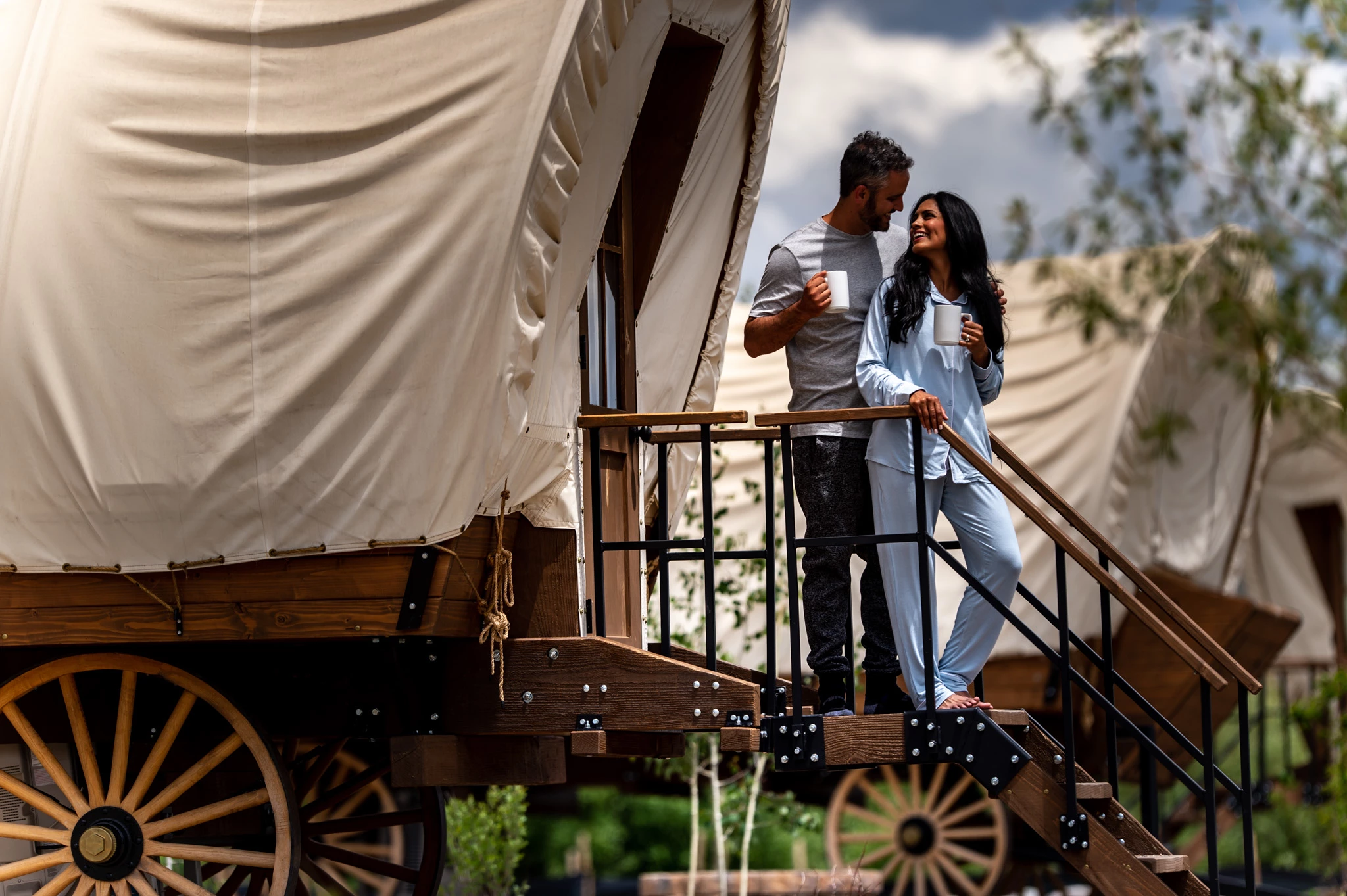 a man and woman standing on a porch of a wagon