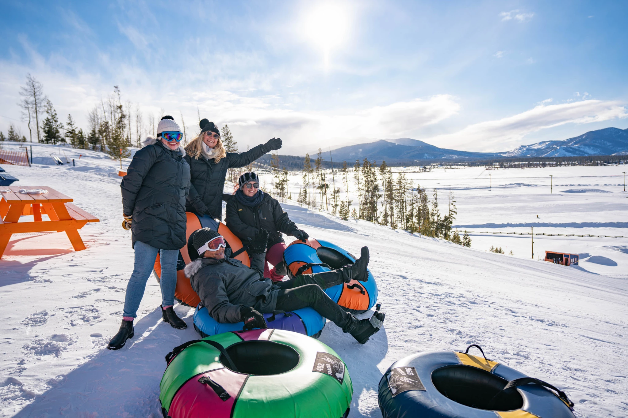 a group of people posing for a picture on snow tubes
