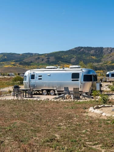 a silver trailer parked in a field