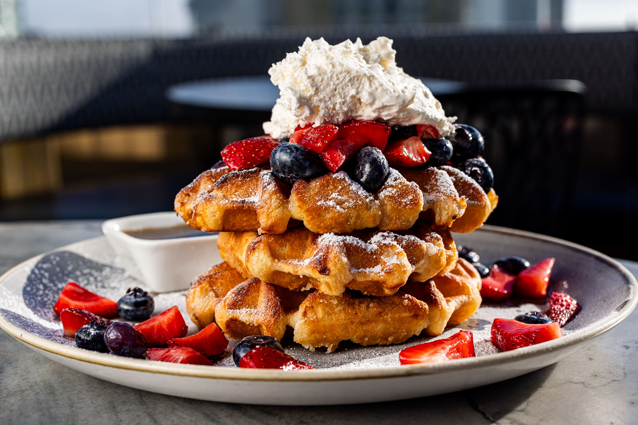 a plate of waffles with strawberries and blueberries