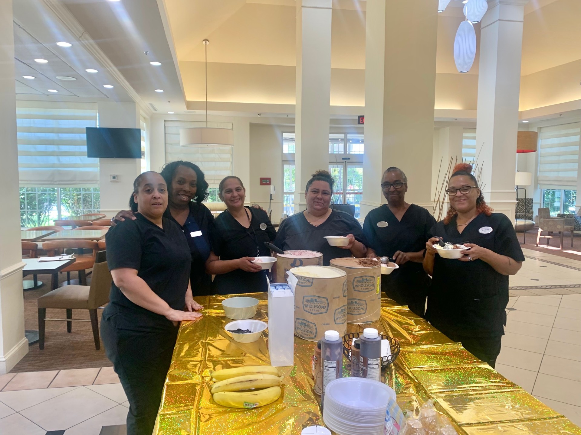 a group of women standing around a table with food