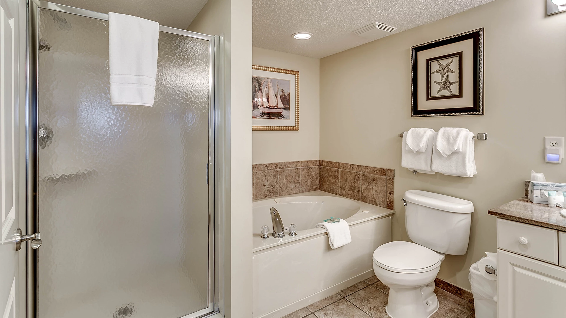 A clean bathroom with a shower, bathtub, toilet, and sink.