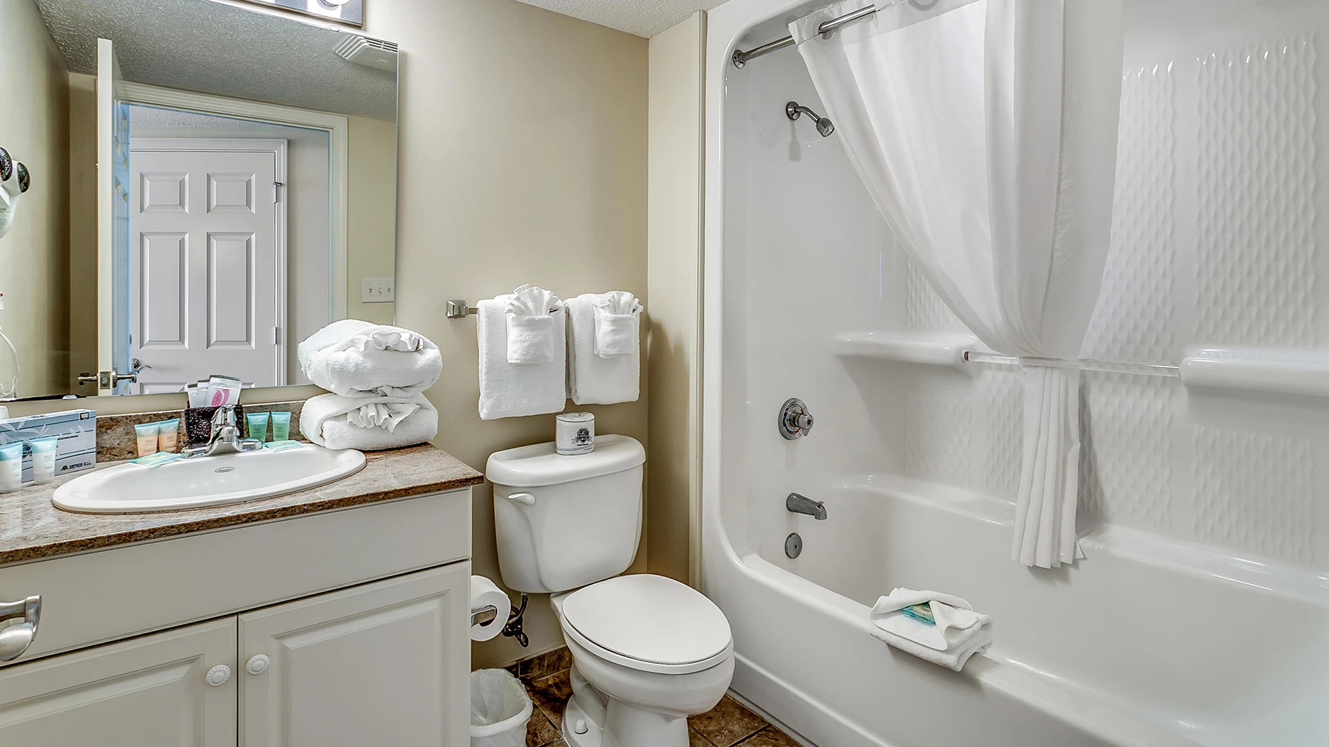 A clean bathroom with a toilet, sink, and shower.
