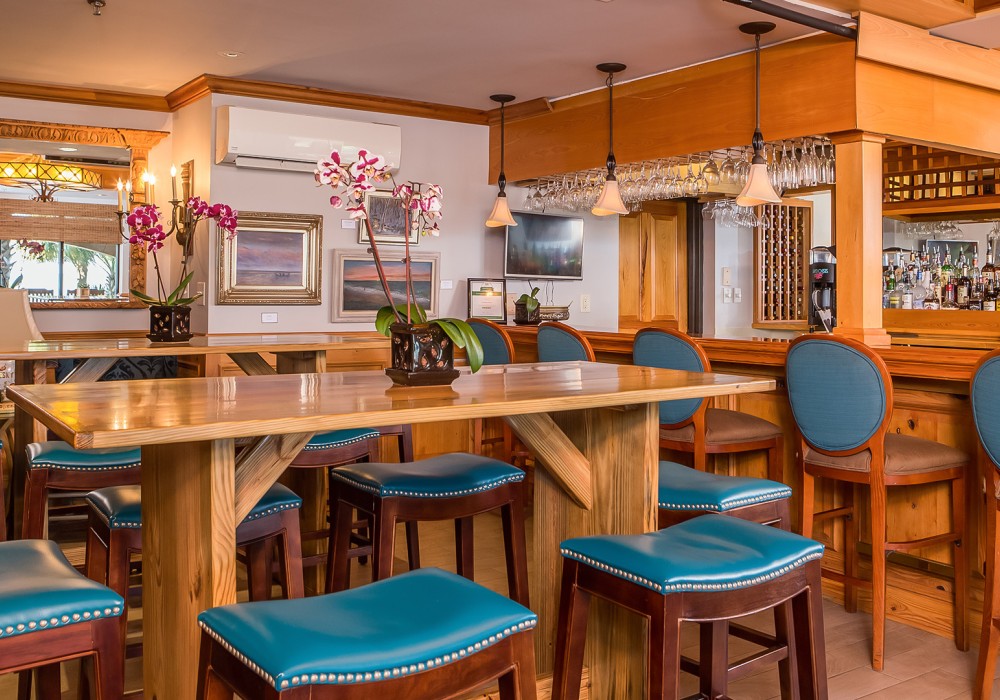 A bar with a wooden table and blue chairs