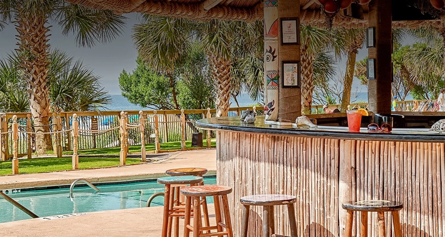 a bar with stools and a pool