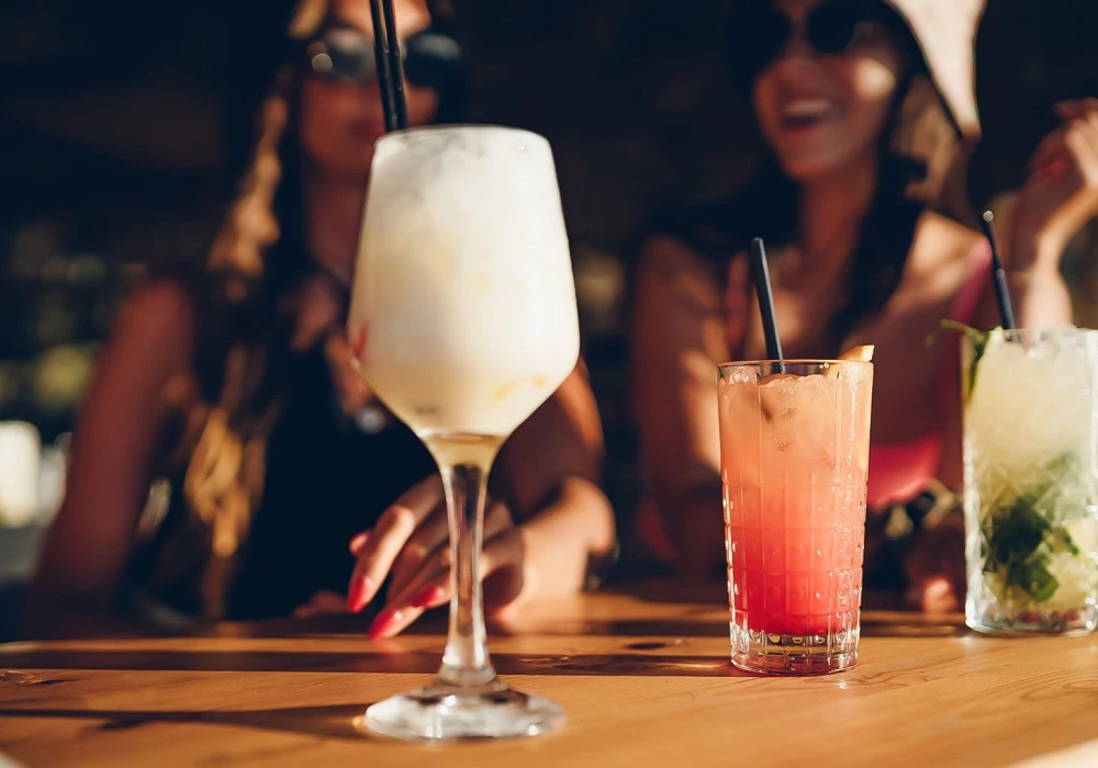 two women sitting at a table with drinks