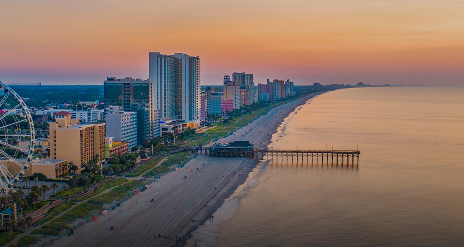 a beach with buildings and a pier
