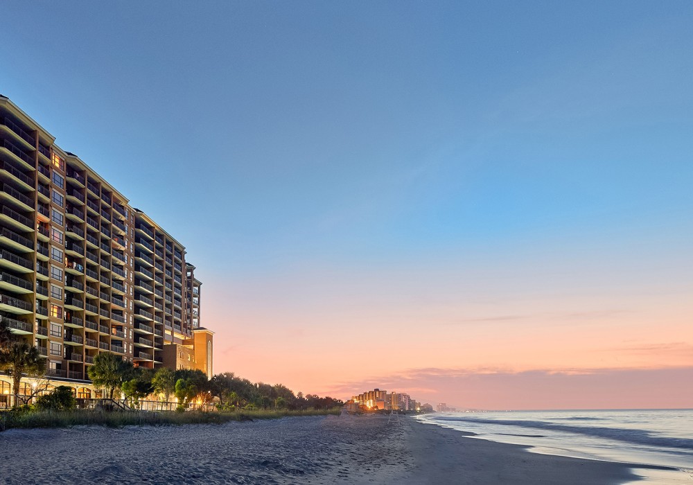 a beach with buildings and trees