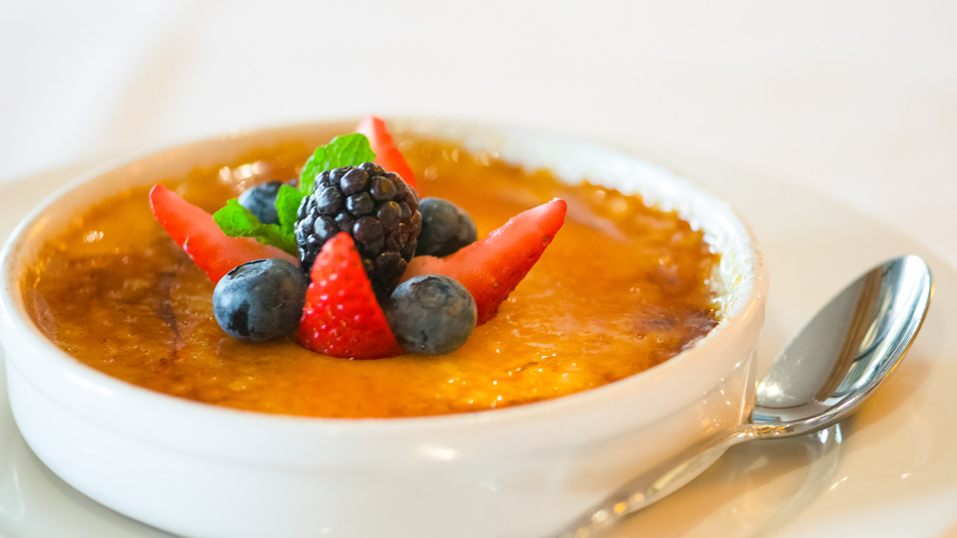 a bowl of creme brulee with berries