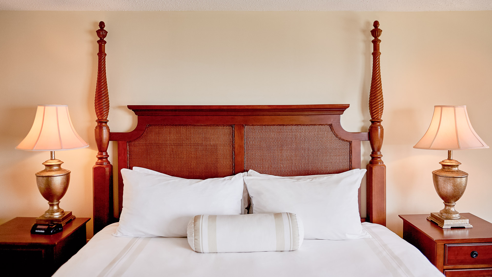 a bed with white pillows and a wooden headboard
