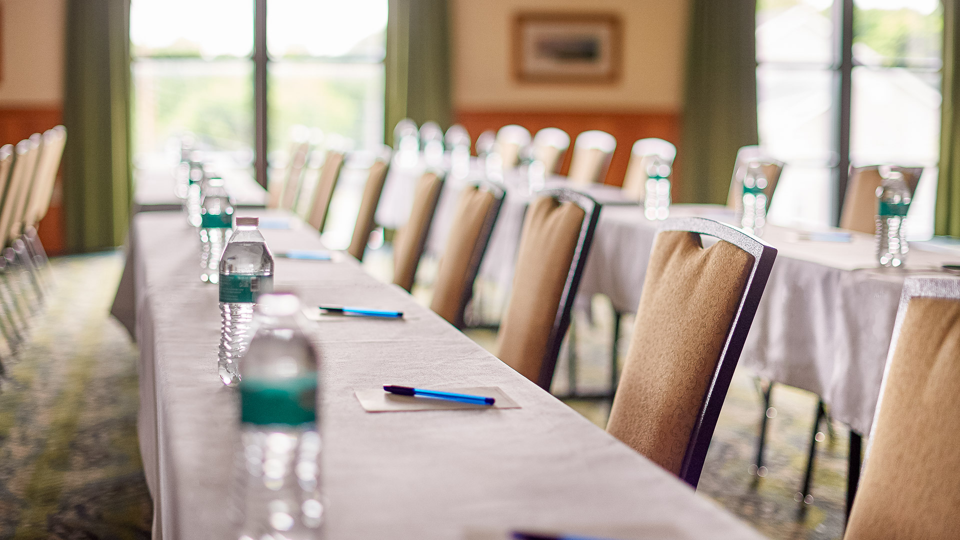a long table with chairs and a few water bottles